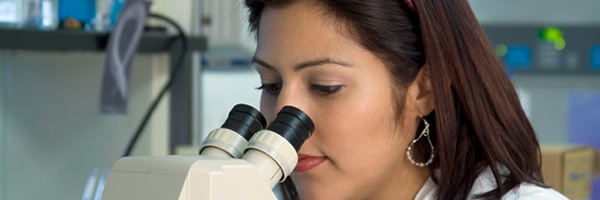 woman in lab using microscope