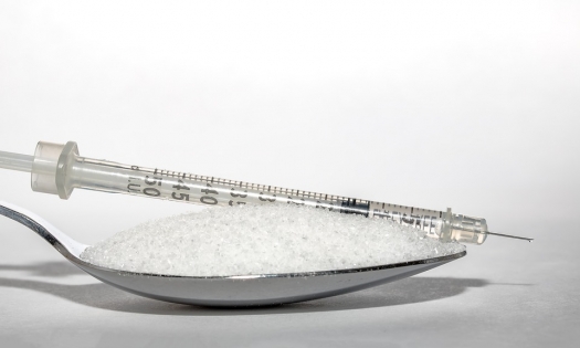 spoon of sugar and insulin syringe