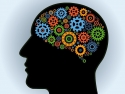 silhouette of human head with colorful gears in brain area