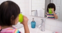 child drinking water at bathroom sink