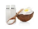 Fresh coconut, 2 bottles with coconut oil, and wooden spoon
