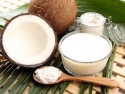 Coconut and coconut oil in jar on leaves and wooden lattice background