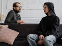 Therapist and youth seated on either side of a couch and talking