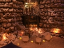 three crystal singing bowls on floor of salt cave lit by candles