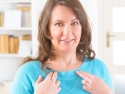 woman tapping on her collar bone with two fingers on each hand 