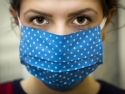 person with brown eyes wearing blue cloth face mask