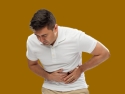 person bending over holding stomach area in pain