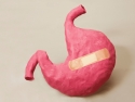 illustration of a pink stomach with a bandaid