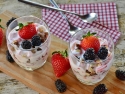 yogurt mixed with strawberries and blackberries in glass dessert dishes