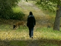 woman walking in woods with dog